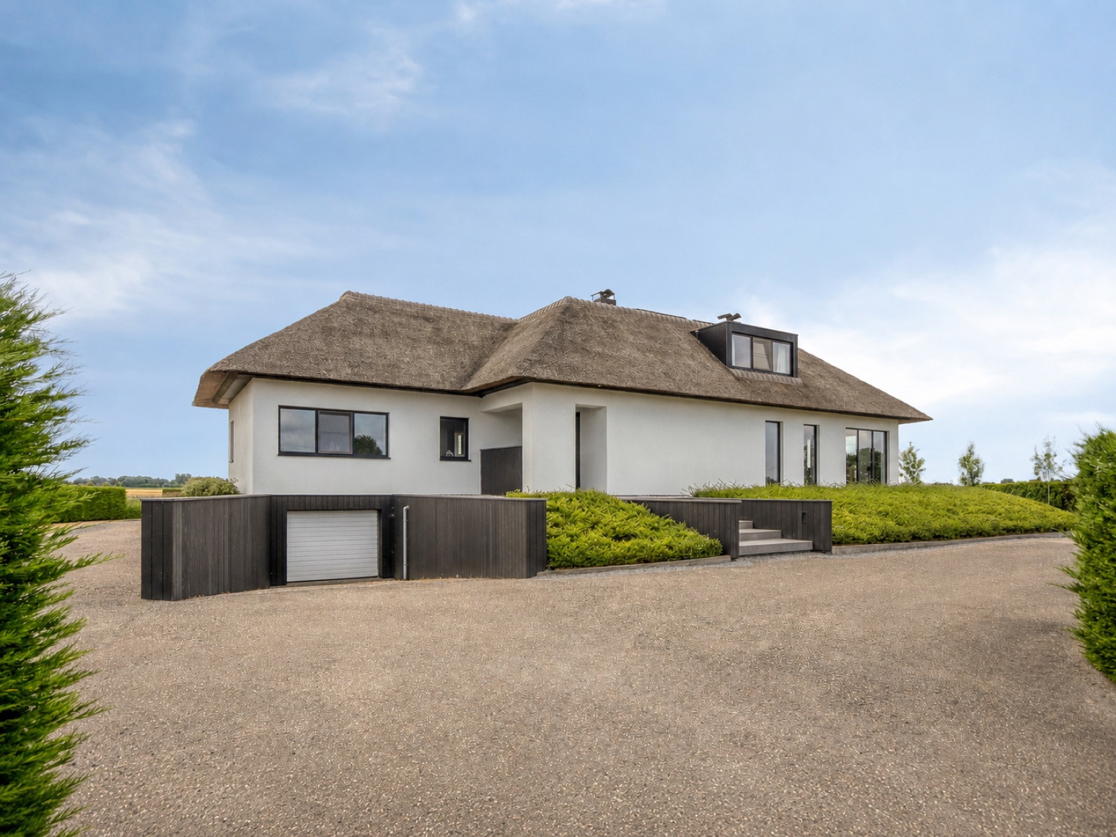Voorzijde met oprit, garage en vrij zicht over de velden